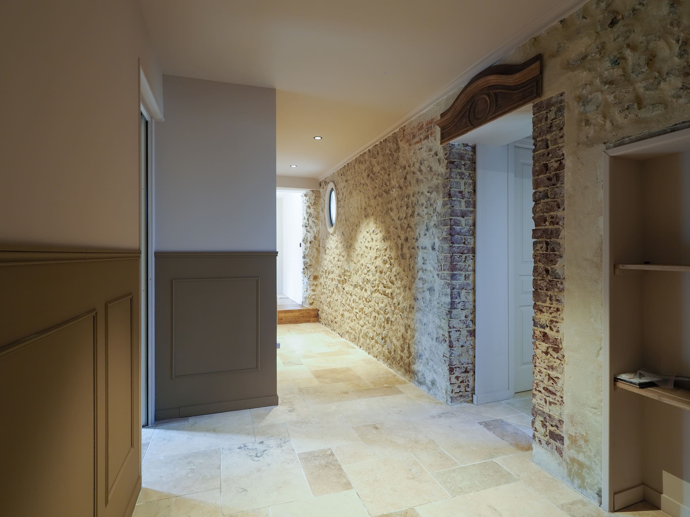 Le couloir, son sol en pierre et son mur de silex et de brique