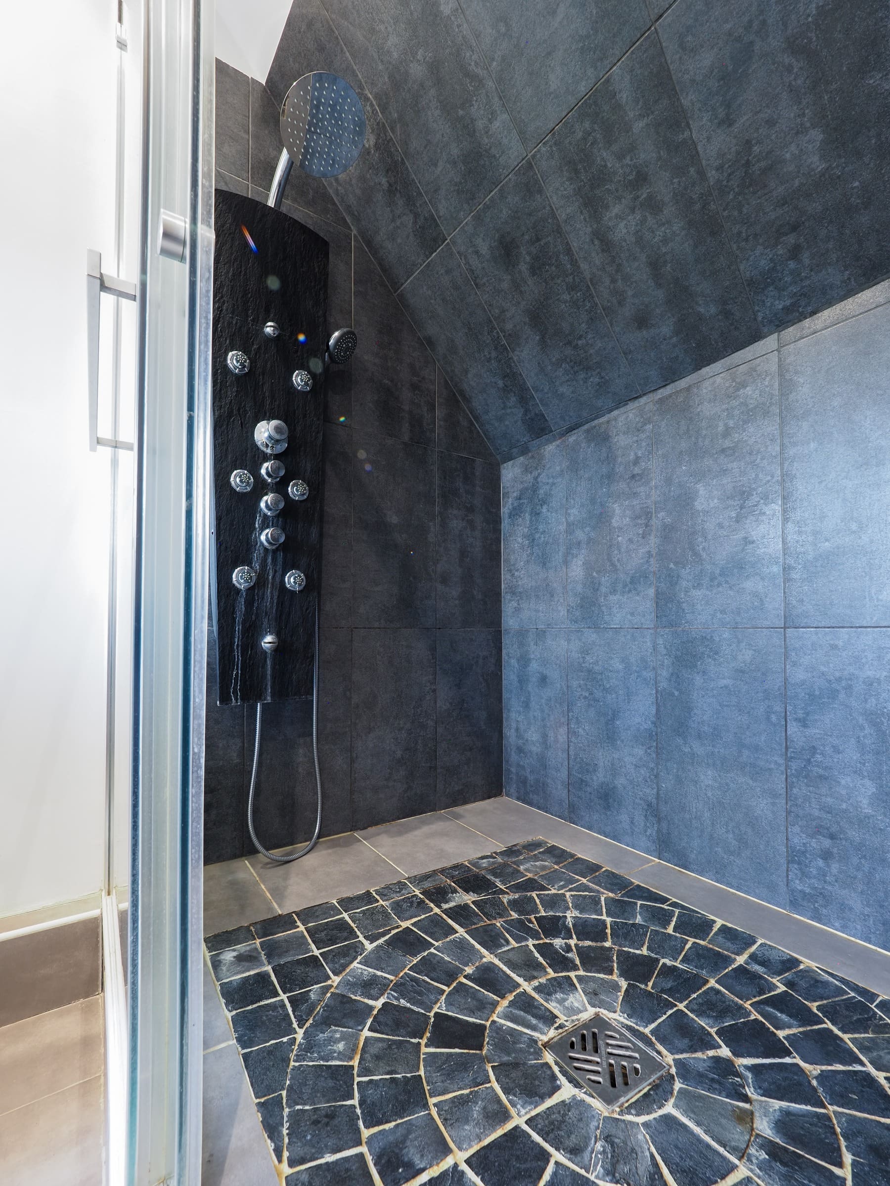 La grande douche à l’italienne de la Junior Suite, galets au sol