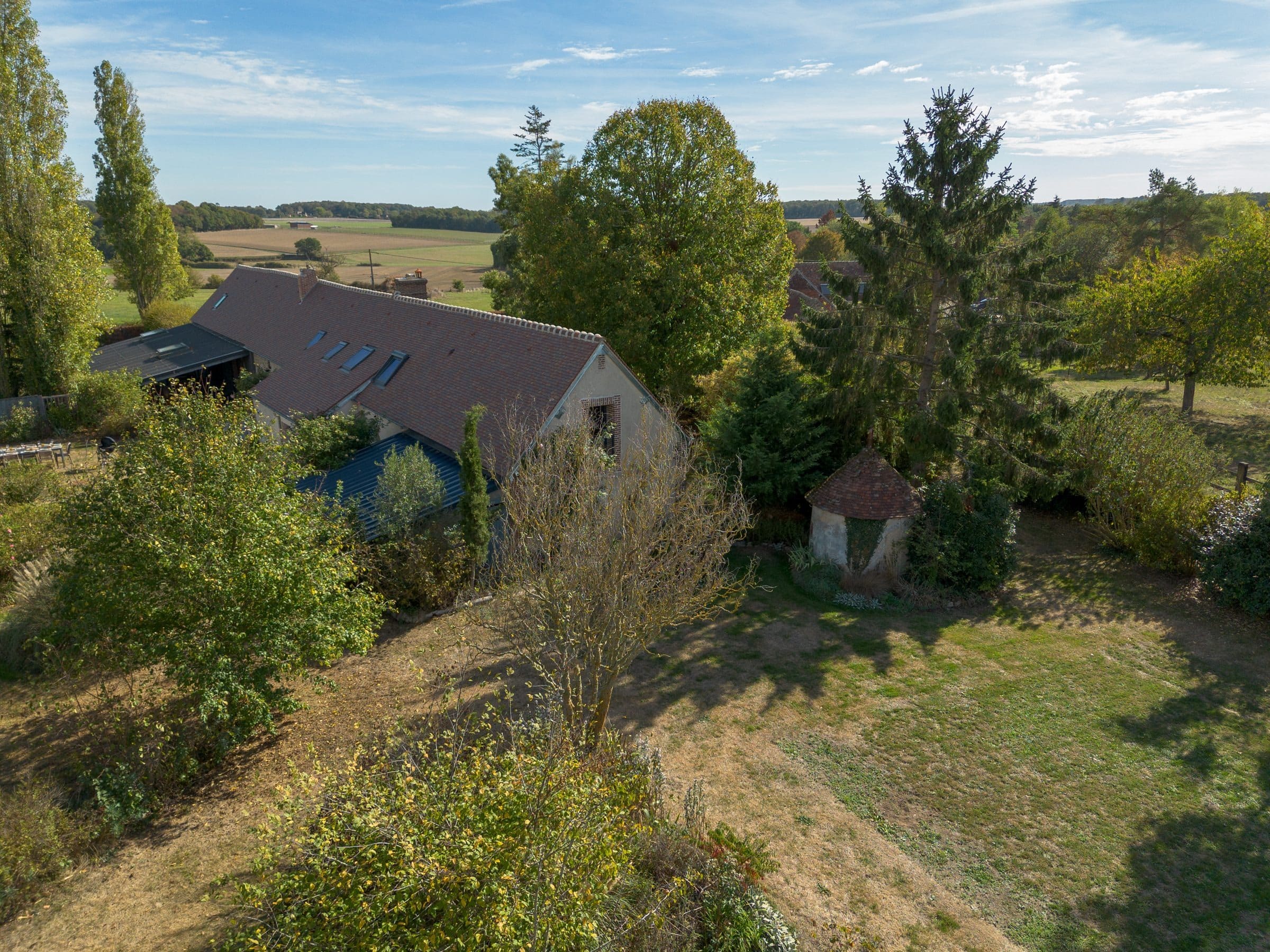 Vue aérienne de la maison entre les arbres et les champs
