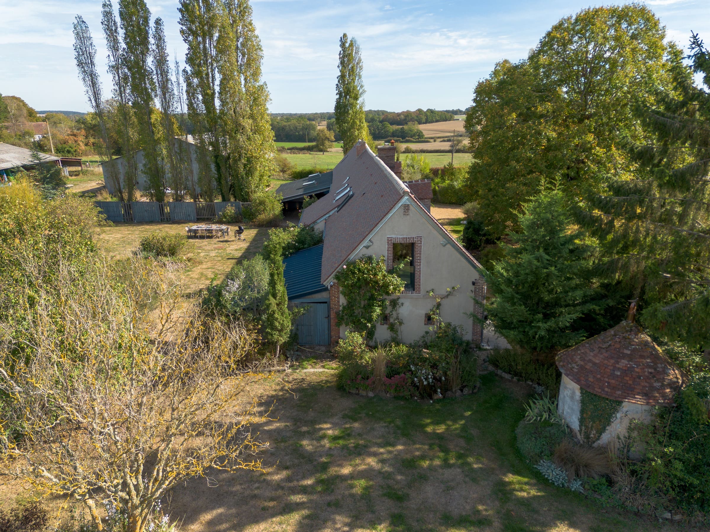 Le pignon de la longère vu du ciel, entre les arbres du jardin