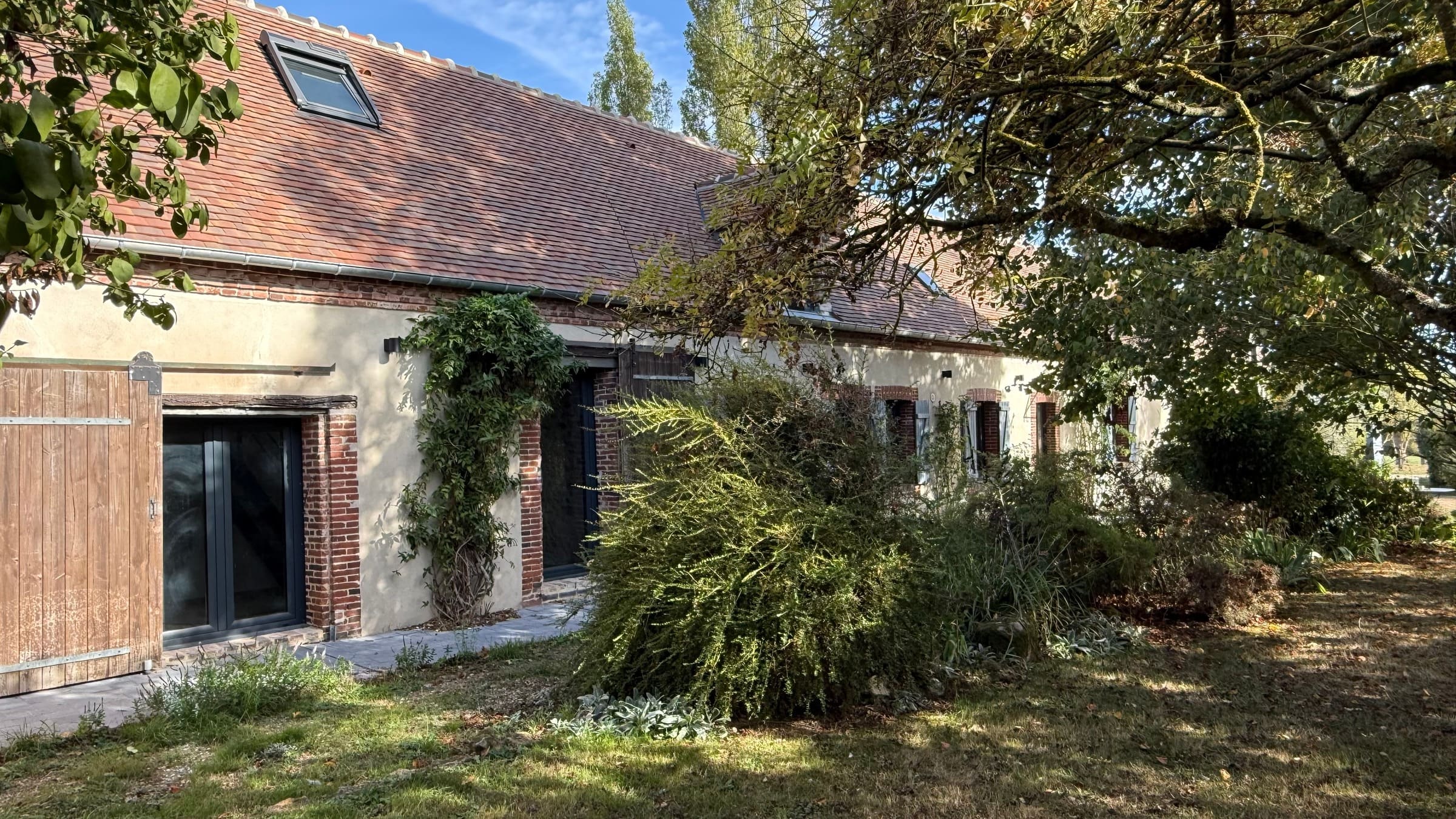 La façade sud à l’ombre des arbres du jardin