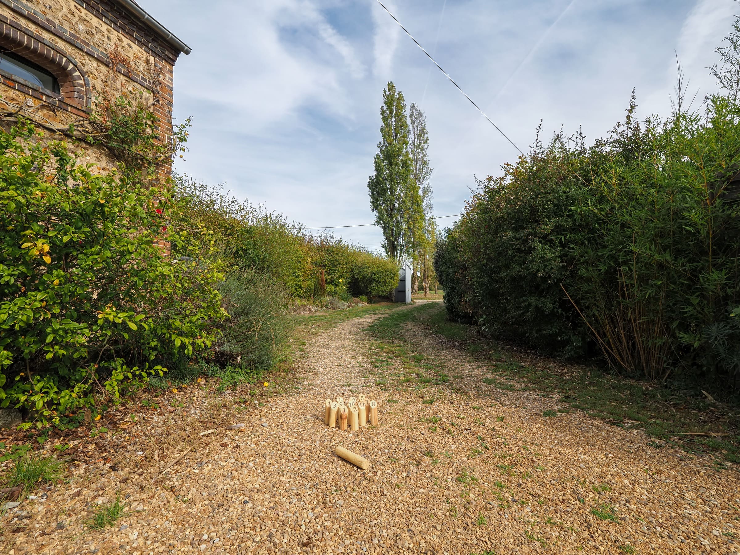 Les quilles du Mölkky dans l’allée du jardin, entre les haies