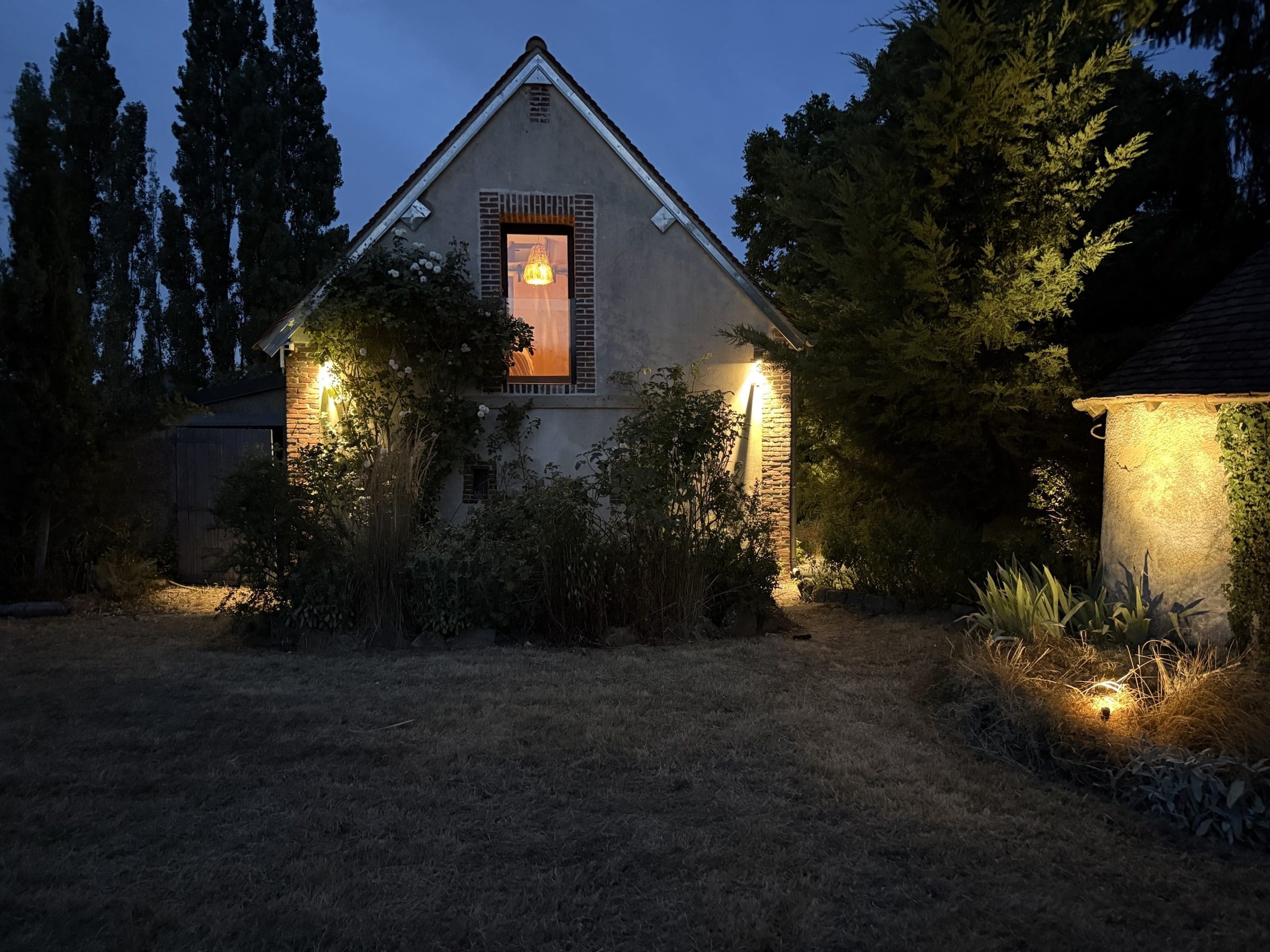Le pignon de la maison éclairé à la tombée de la nuit