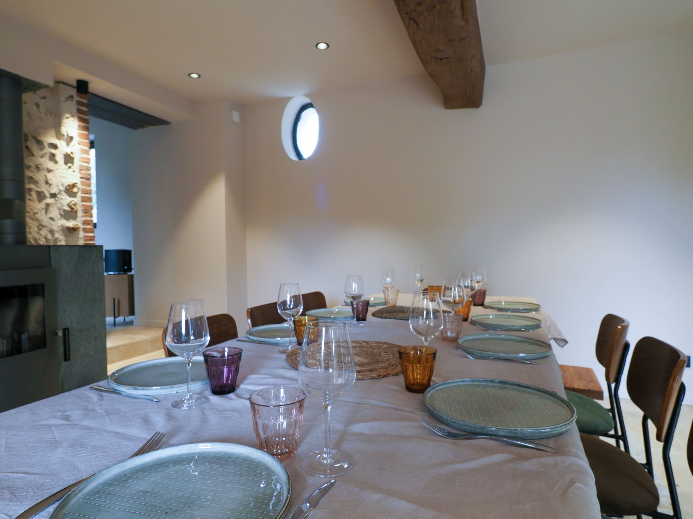 La table de la salle à manger dressée, le poêle à l’arrière-plan