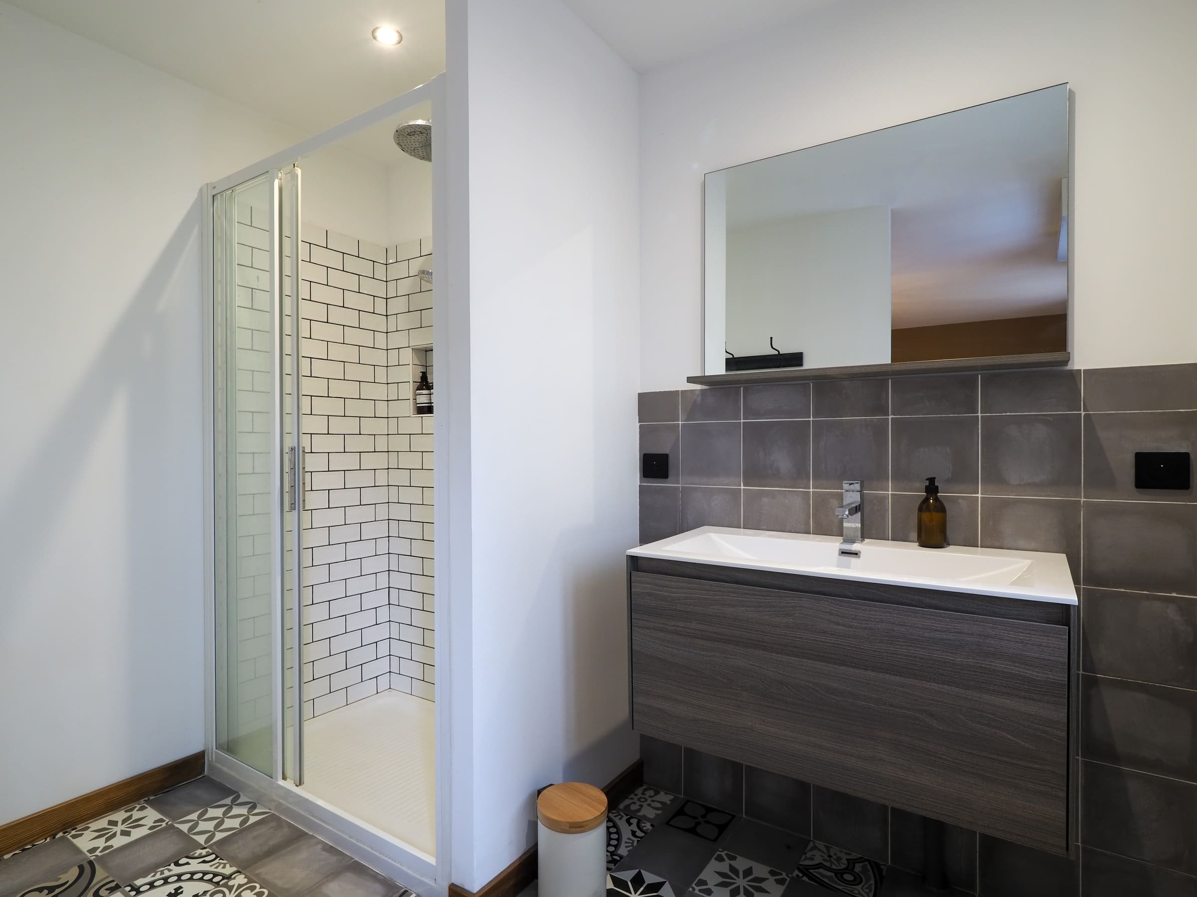 La salle d’eau de la Chambre Deluxe : douche, vasque et carreaux de ciment